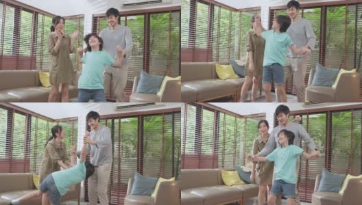 幸福快乐的亚洲家庭，爸爸妈妈和儿子滑稽的舞蹈在客厅在家里。有趣的时刻，在家跳舞，一起享受节日。亚洲家庭共度美好时光的概念。高清在线视频素材下载