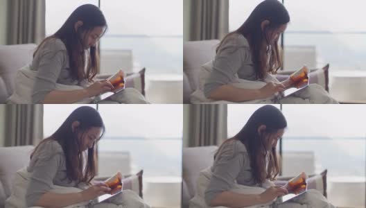 年轻的亚洲妇女拿着药瓶，在家里打电话高清在线视频素材下载