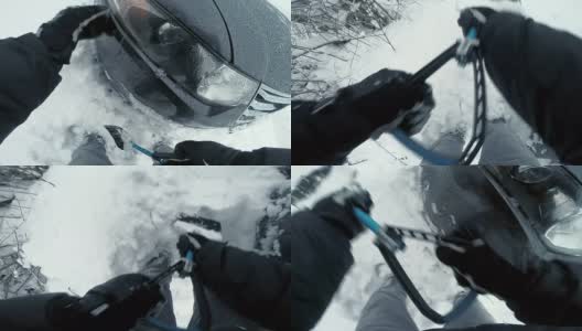 男子用铲子把车从雪中挖出来高清在线视频素材下载
