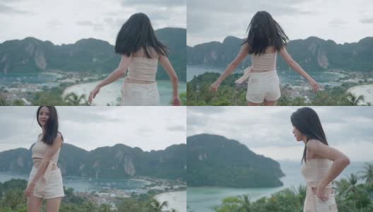 年轻活跃的亚洲女孩跳舞在山顶俯瞰美丽的岛屿观点，自由的生活方式逃离繁忙拥挤的城市，遥远的夏季岛屿跳旅行者高清在线视频素材下载