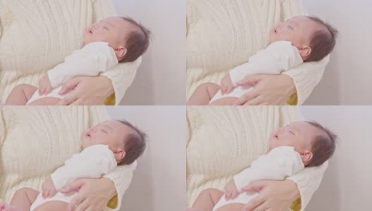 可爱的睡着的新生儿放松在妈妈的手臂安全舒适。微笑亚洲新生儿宝宝休息睡觉香甜的梦。母亲抱着婴儿。新生儿的概念高清在线视频素材下载