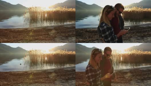 一对年轻夫妇在湖边发短信高清在线视频素材下载
