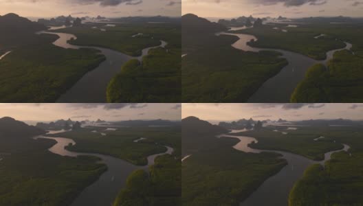 在泰国攀牙湾的红树林和茂密的雨林上空，可以看到多山的岛屿和海洋上引人注目的橙色日出高清在线视频素材下载