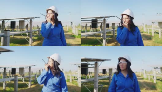 图片:亚洲中年工程师，蓝色防护服，带工具箱修理太阳能电池板，呼叫团队帮助，太阳能电池板农场，正面高清在线视频素材下载