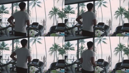 一名亚洲男子早上在度假健身中心的跑步机上锻炼。高清在线视频素材下载