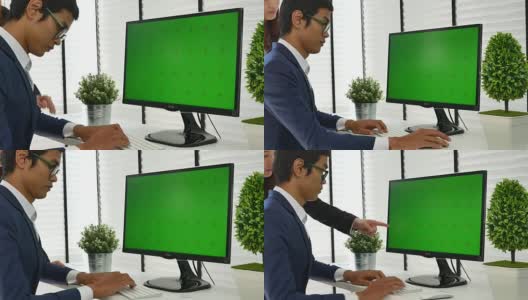 Two people using at the computer with green screen高清在线视频素材下载