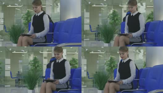 带着平板电脑的微笑女人坐在客户服务区高清在线视频素材下载