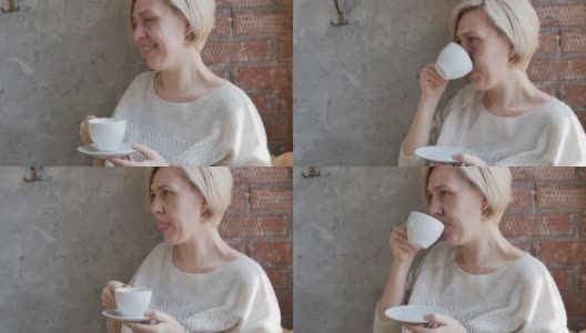 白种人成年金发女人从一个杯子喝茶，听点头她的头高清在线视频素材下载