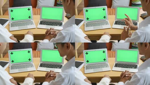 两人用绿屏笔记本电脑讨论高清在线视频素材下载