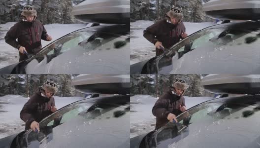 年轻人正在清理雪地里的汽车高清在线视频素材下载