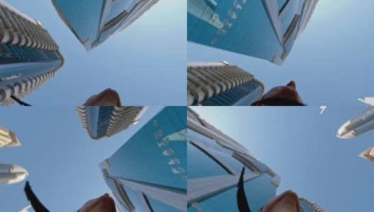 在迪拜摩天大楼下旋转的人高清在线视频素材下载
