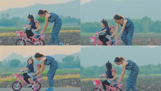 妈妈和她的女儿一起骑着自行车在乡下高清在线视频素材下载