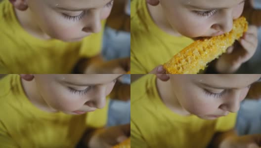 一个穿着黄色t恤的男孩一边吃着黄色的煮玉米一边看电视高清在线视频素材下载
