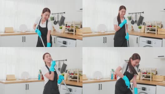 亚洲清洁服务女孩唱歌，而清洁厨房在家里。美丽的年轻快乐的女人管家清洁工跳舞和拖地工作，家务或家务在家里。高清在线视频素材下载