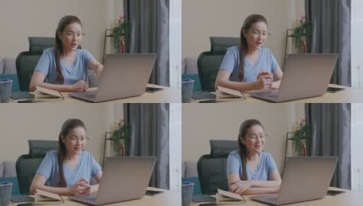 亚洲自由职业妇女戴着耳机在视频电话聊天在家里工作。高清在线视频素材下载