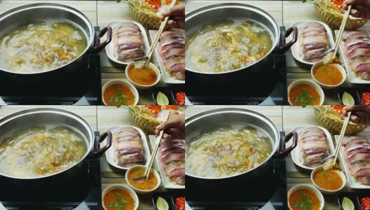 吃泰国菜的亚洲人。在一锅热水中放入鱼肉高清在线视频素材下载