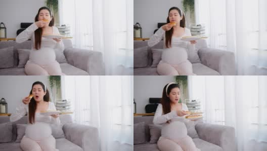 孕妇在家吃不健康的披萨。高清在线视频素材下载
