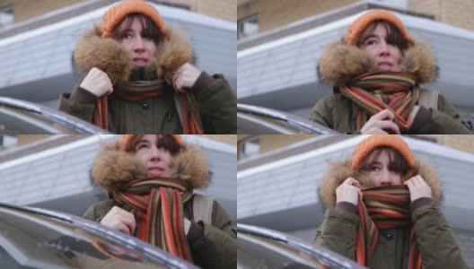 一个女人在冬日小镇的街道上等待着高清在线视频素材下载