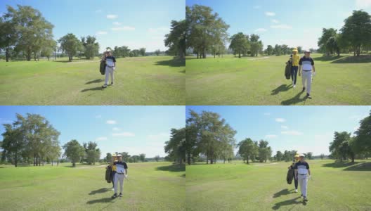 4K亚洲男子高尔夫球手与女球童在高尔夫球场上行走高清在线视频素材下载