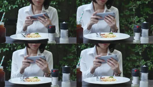 一名女子在餐馆拍摄意大利面高清在线视频素材下载