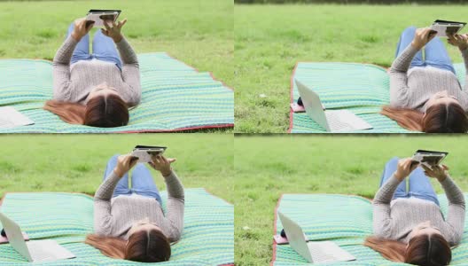 快乐的女学生带着笔记本电脑在公园里，摄影车拍摄高清在线视频素材下载