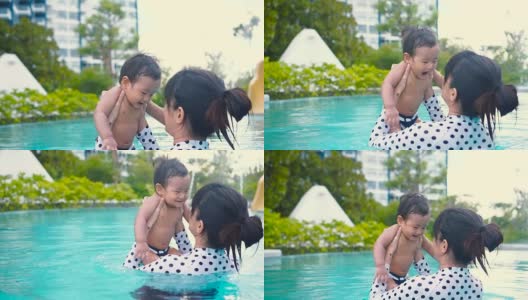 一个小男孩和妈妈在游泳池里玩耍和游泳高清在线视频素材下载