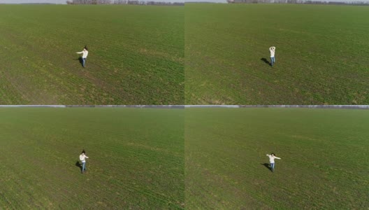 快乐的女人在绿色的田野上蹦蹦跳跳，空中飞翔高清在线视频素材下载