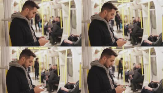 年轻人在地铁里打电话，用智能手机玩游戏，用手机发短信，用手机浏览社交媒体，用一只手玩游戏，戴着耳机听音乐高清在线视频素材下载