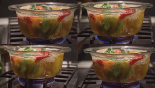 在烧开的水里煮填好的辣椒，放在炉子上一个透明的平底锅里，多利拍高清在线视频素材下载