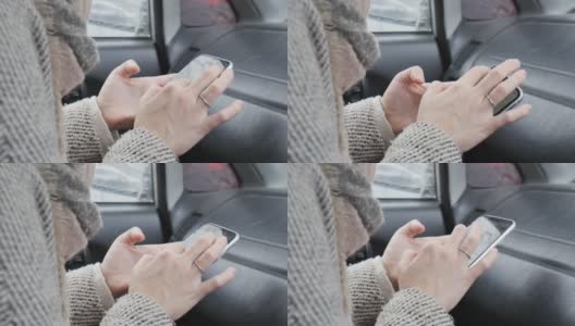 穿着外套的女人的手用手指按在智能手机上高清在线视频素材下载
