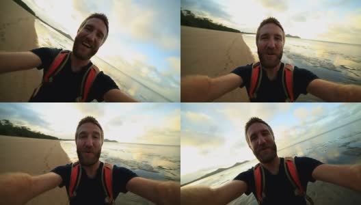 一个兴高采烈的年轻人在海滩上拍自拍照高清在线视频素材下载