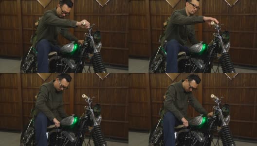 一名男子坐在他定制的摩托车上，在他的车库里发动引擎高清在线视频素材下载