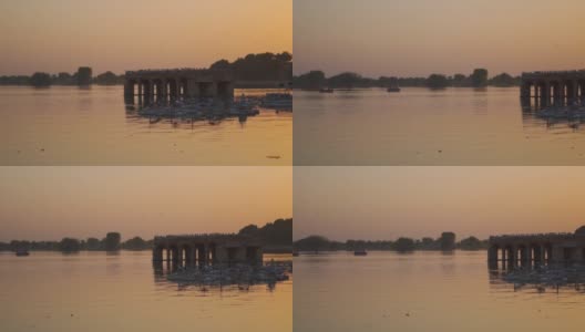 在印度拉贾斯坦邦的斋萨尔梅尔，日落时游客们在湖中央划船的Gadisar湖的景色。高清在线视频素材下载