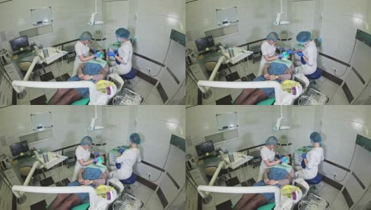 一名妇女在牙科诊所接受牙科治疗以补牙洞。牙科修复与复合材料聚合紫外光与激光。高清在线视频素材下载