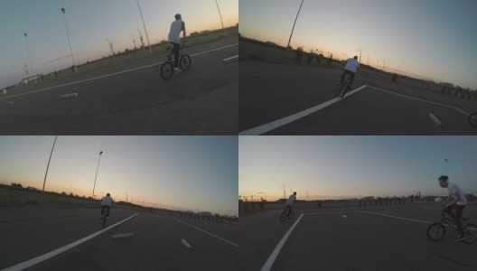 骑自行车的观点和他的十几岁的朋友在自行车上表演特技和特技在特殊的轨道自行车高清在线视频素材下载