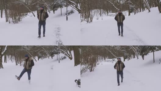 年轻英俊漫步冬季公园高清在线视频素材下载