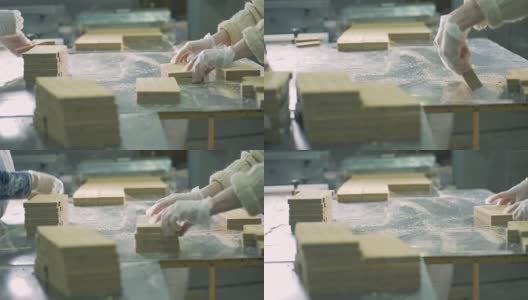 两名工人在工厂里把华夫饼放在砖头里。4 k。高清在线视频素材下载