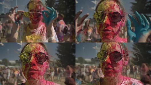 年轻快乐的女孩穿着五颜六色的粉是戴着太阳镜在胡里节的白天在夏天，色彩概念高清在线视频素材下载