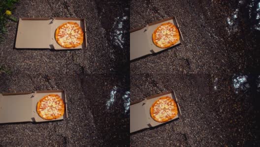 在卵石滩上放着披萨的纸箱。高清在线视频素材下载
