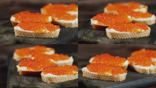 带有红鱼子酱的三明治在切菜板上旋转。高清在线视频素材下载