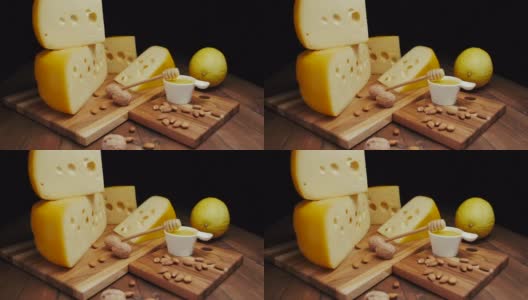 中等硬度的奶酪头，伊达豪达干酪放在木板上，加坚果和蜂蜜。幻灯片拍摄高清在线视频素材下载