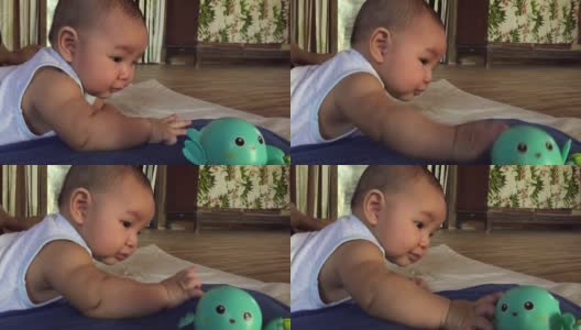 可爱的亚洲新生儿小婴儿躺在床上玩玩具高清在线视频素材下载