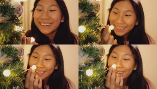 快乐的亚洲女孩戴着驯鹿发带，晚上在家玩圣诞灯，庆祝节日的概念。高清在线视频素材下载