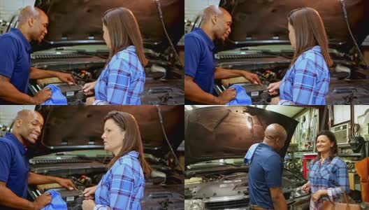 机械师在汽车修理店向客户讲解汽车维修。高清在线视频素材下载