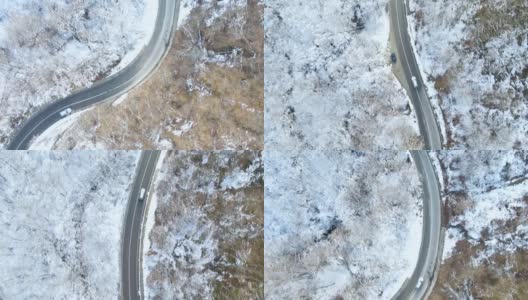 鸟瞰图的冬季道路与汽车和积雪覆盖的森林高清在线视频素材下载