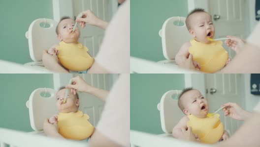 可爱的亚洲婴儿吃婴儿食品，小男孩噎住，呕吐高清在线视频素材下载