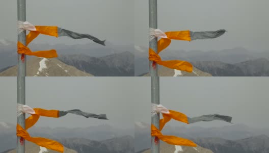 一根五彩缤纷的彩带在山上的一根杆子上摇摆高清在线视频素材下载