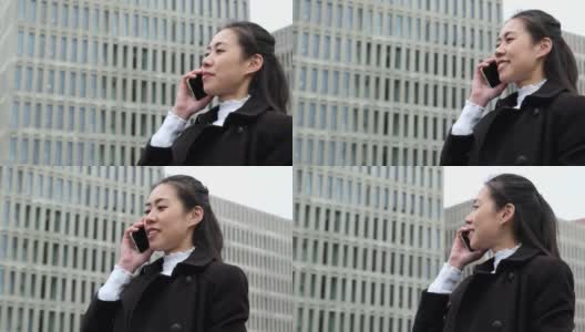 中国企业家在摩天大楼旁用手机讲话高清在线视频素材下载