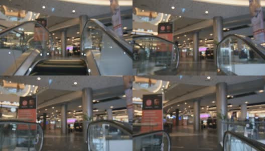 用散景模糊的抽象镜头拍摄购物中心移动的自动扶梯高清在线视频素材下载