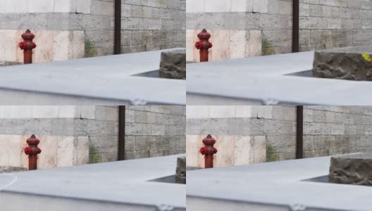 红色消火栓以古砖石墙为背景，水平运动高清在线视频素材下载